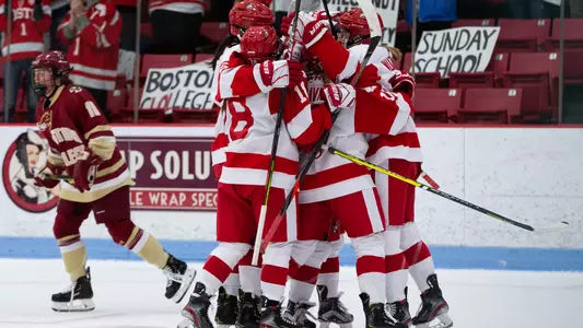 The BU women's ice hockey team celebrates a goal against Boston College