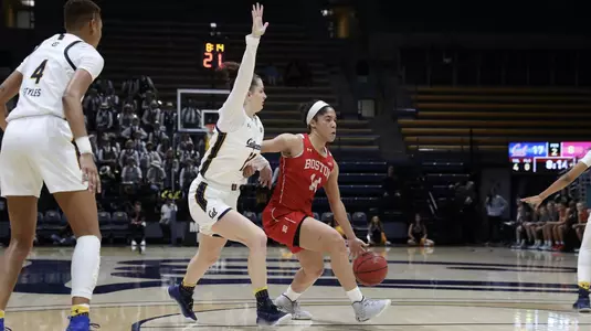 Sydney Johnson dribbling against a Cal defender at the top of the key