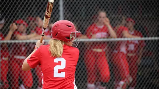 Emily Gant gets ready for a pitch at the plate - The camera angle is at her back.