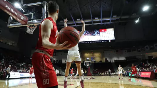 Tyler Scanlon gets ready to make a long pass on the inbounds with an Elon defender jumping up and down.