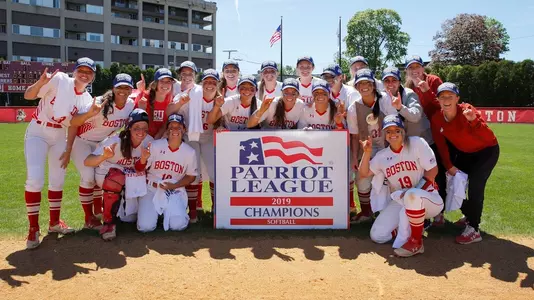 Boston University celebrates as the 2019 Patriot League Softball Champions with the trophies and championship sign.