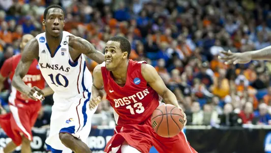 D.J. Irving dribbles up the court toward the hoop with a Kansas defender on his right.