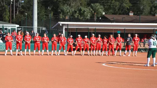 BU softball lines up along the first base line for the national anthem at Stetson.