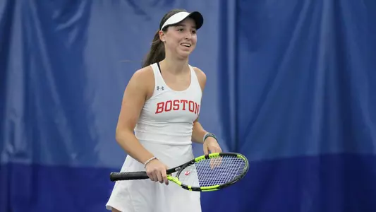 Erica Di Battista smiles with the racquet in her right hand after a point is completed.