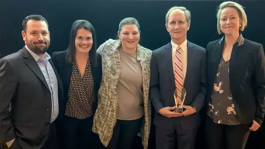 Mike Scire, Liz Keady Norton, Abby Ostrom, Brian Durocher and Tara Watchorn pose for a picture after Durocher won the 2020 Ace Bailey Good Guy Award