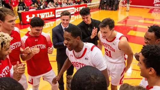 The Boston University men's basketball team gathers in a circle with Walter Whyte in the middle following introductions against Northeastern.