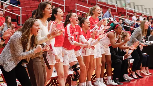 Women's basketball bench cheering enthusiastically