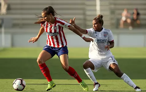 Kylie Strom controlling the ball with a defender nearby
