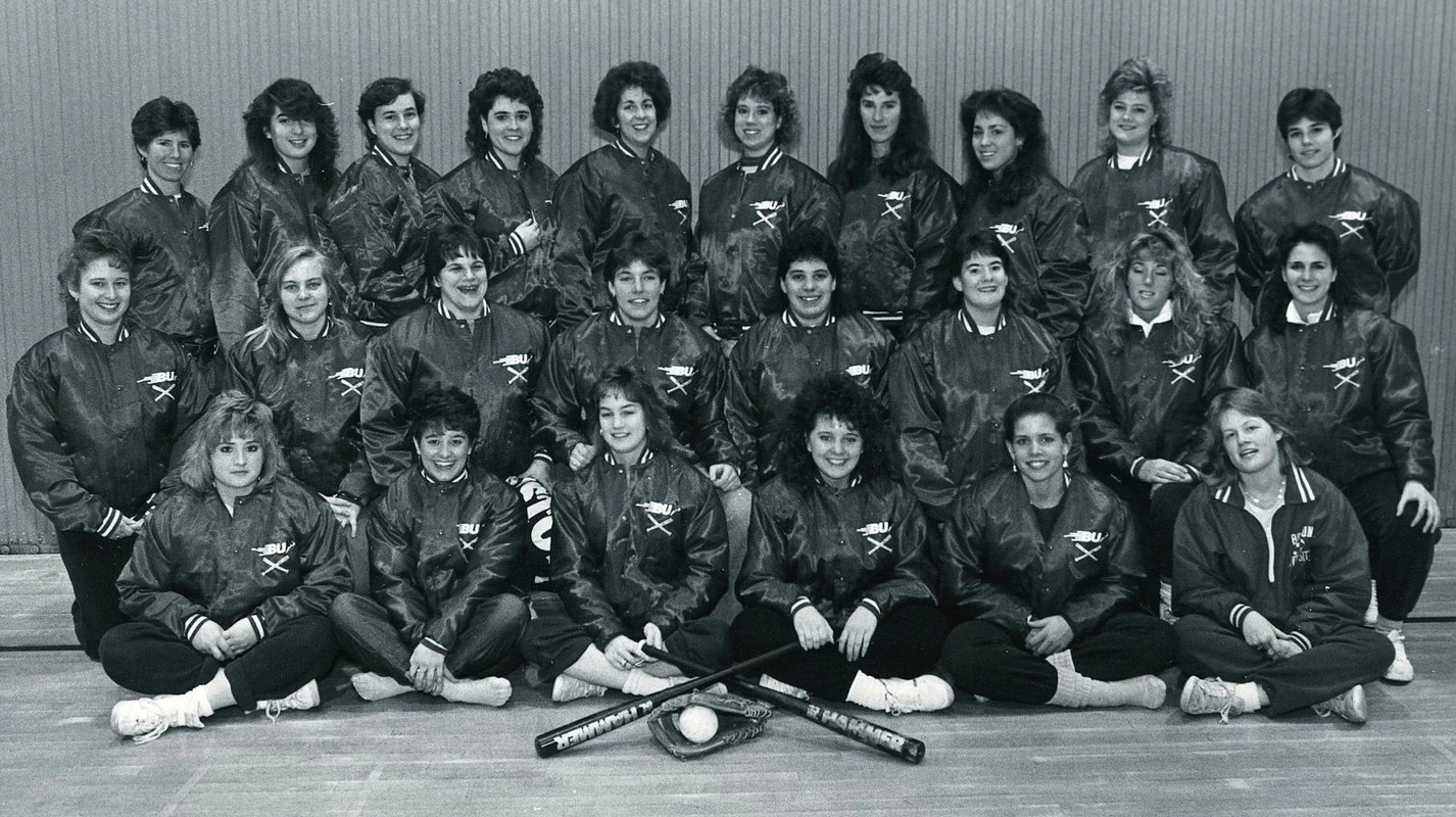 The 1988 Boston University softball team lines up in three throws with the front sitting and second kneeling for a team photo.