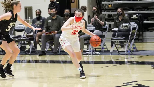 Maggie Pina dribbling the ball on the wing with an Army defender nearby