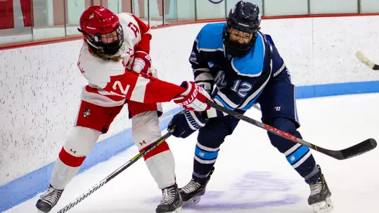 Kaleigh Donnelly battles a Maine player for the puck