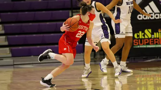 Maggie Pina dribbling to the key while a defender tries to guard her