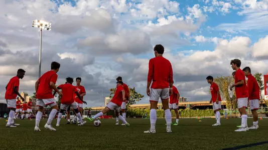 Members of the men's soccer team gather in a circle to kick the ball around during pregame routine.
