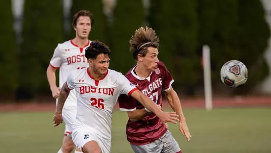 Danny Rosario battles a Colgate player for the soccer ball as it bounces on the field.