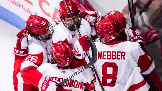 The men's ice hockey team celebrates a goal