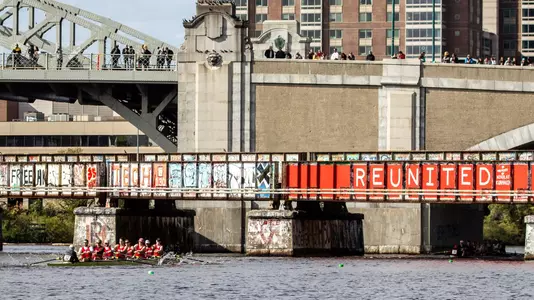 BU men's rowing boat heads under the BU bridge during head of the charles.