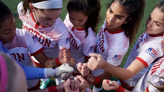 The women's soccer starting XI huddle up before their match against Loyola.