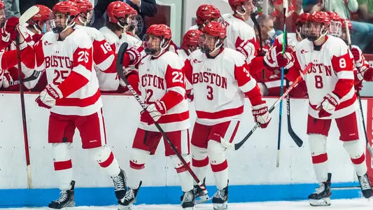Men's Ice Hockey Players high-five their teammates on the bench after a goal