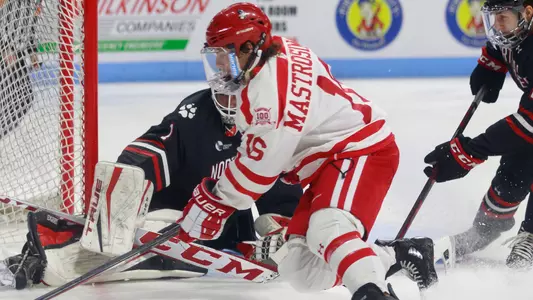 Robert Mastrosimone skating in front of the Northeastern goalie