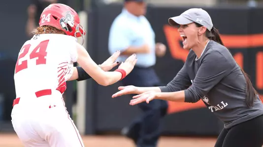 Ashley Waters high fives Lauren Nett as Nett rounds third toward home plate on the homer.