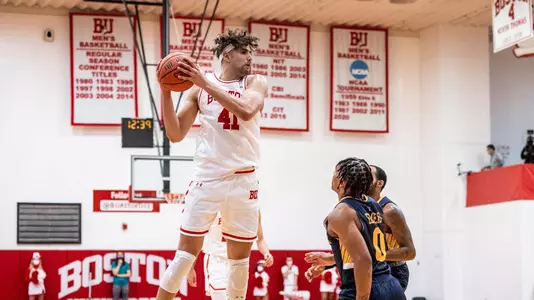 Sukhmail Mathon jumps up to grab the ball with two Merrimack players in front of him.