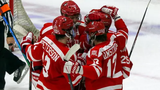 The men's ice hockey team celebrates a goal