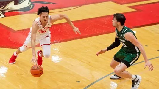 Fletcher Tynen dribbles the ball to his right with a Binghamton defender in front.