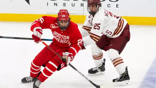 Sam Stevens skating in front of a Boston College player