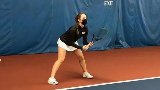 Victoria Carlsten holds the racquet and is positioned waiting for a serve.