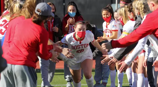 Alyssa Bourgeois running through a tunnel of teammates and high fiving team