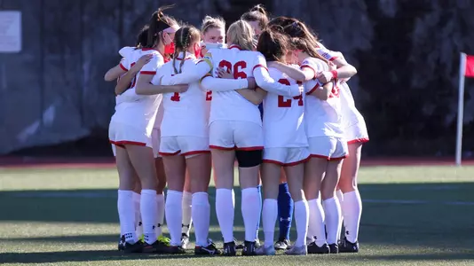 Members of the women's soccer team in a team huddle
