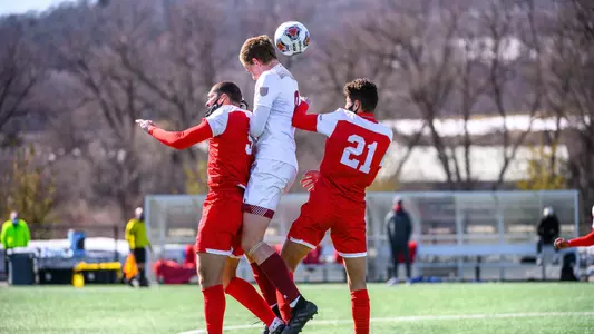 Two men's soccer players jump up for the ball with a Colgate player high in the air.