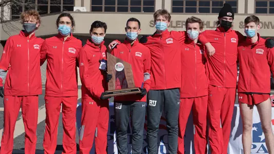 The men's cross country team poses with a Patriot League second-place trophy