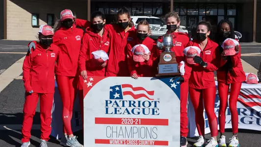 The women's cross country team poses with the trophy after winning the Patriot League Championship
