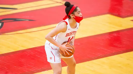 Sydney Johnson holding the basketball at center court