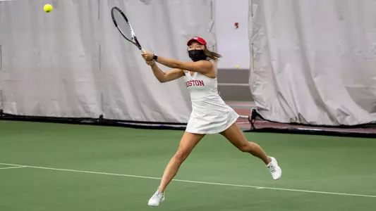 Emily Kim does a leaping backhand to generate power on her hit of the high tennis ball.