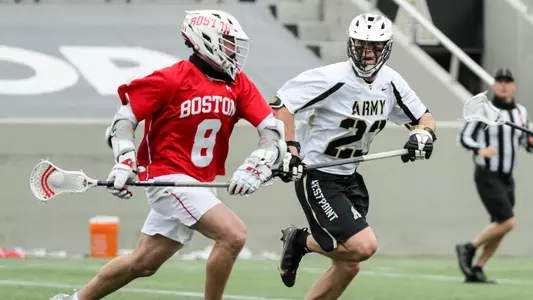 Louis Perfetto playing lacrosse, running near an Army defender