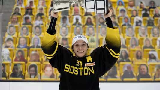 Kaleigh Fratkin smiles as she lifts the Isobel Cup over her head