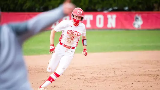 Emily Gant runnings toward third base with head coach Ashley Waters directing her home with an outstretched arm.