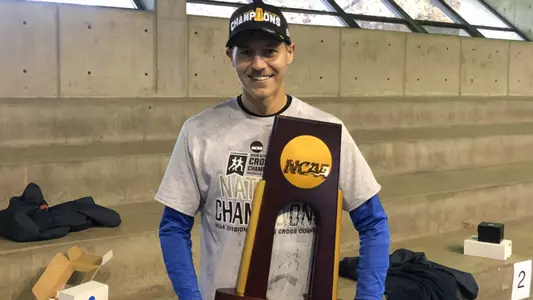Jordan Carpenter holds an NCAA trophy