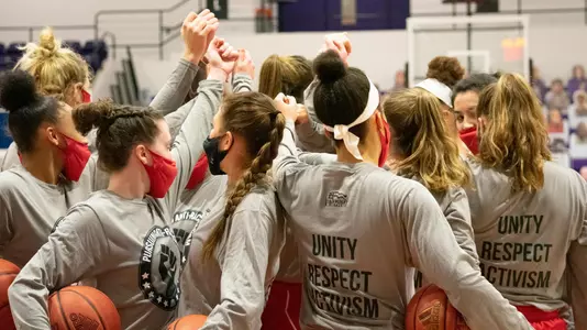 Members of the women's basketball team in a huddle