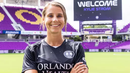 Kylie Strom posing in front of the Orland Pride's field
