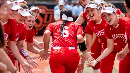 Lauren Keleher runs through a tunnel of her teammates while high-fiving them on both sides.