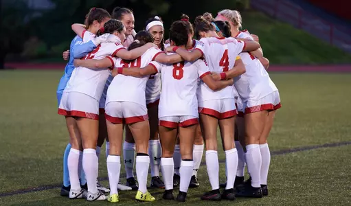 The women's soccer team in a huddle before opening kick