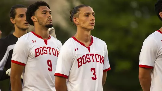 Members of the Boston University men's soccer team line up for the national anthem.