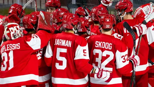 The men's ice hockey team celebrates a win