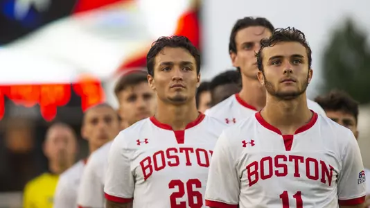 Members of the Boston University men's soccer team are linedup in front of the video board for the National Anthem.