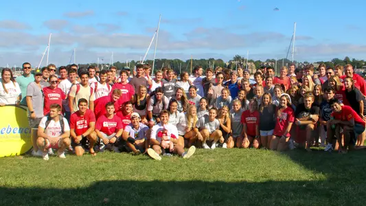 The men's and women's lacrosse teams pose for a group photo in Newport, Rhode Island, at the conclusion of Bike to the Beach