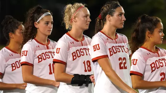 Women's soccer players lined up for the national anthem
