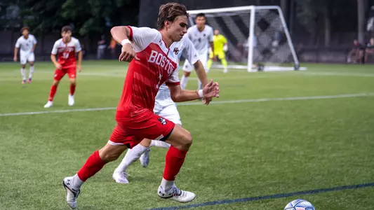 Quinn Matulis chases after the ball with a Boston College defender right next to him.